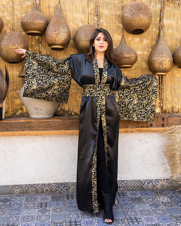 Elegant black satin kaftan with brocade detailing by Aya Osama Couture, perfect for special occasions and evening wear.